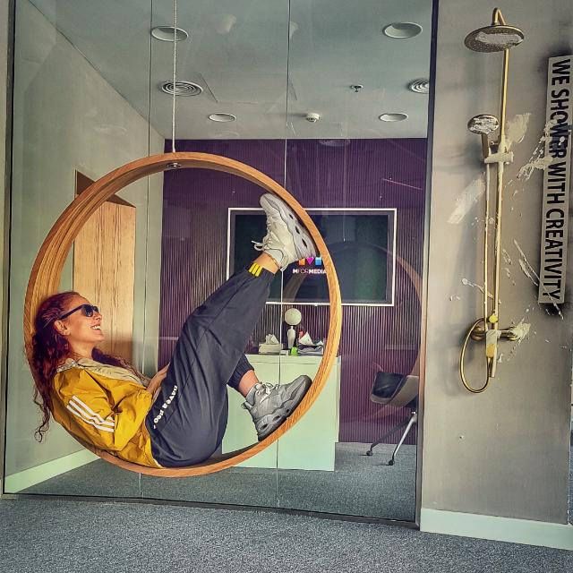 Maya Kmayra seated in a circular swing